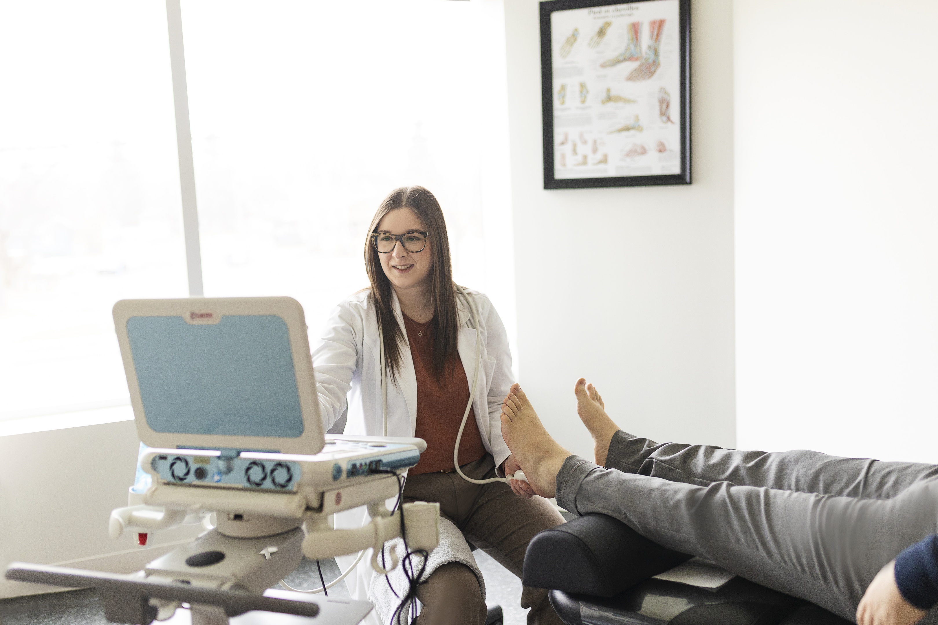 Podiatre qui fait une échographie sur le talon d'un patient.